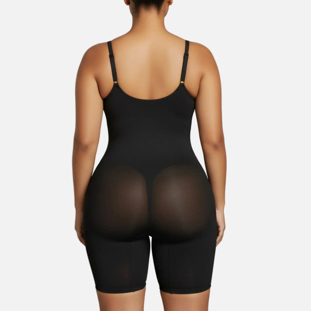 Person wearing a black bodysuit against a plain background